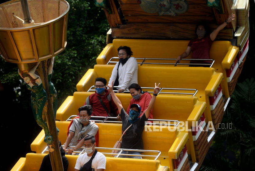 Pengunjung menaiki salah satu wahana di Dunia Fantasi, Ancol, Jakarta, Senin (12/10). Setelah sempat ditutup sejak 14 September 2020 karena penerapan PSBB di Ibukota, kini kawasan wisata Ancol kembali dibuka seiring dicabutnya status PSBB Jakarta menjadi PSBB transisi.Prayogi/Republika.