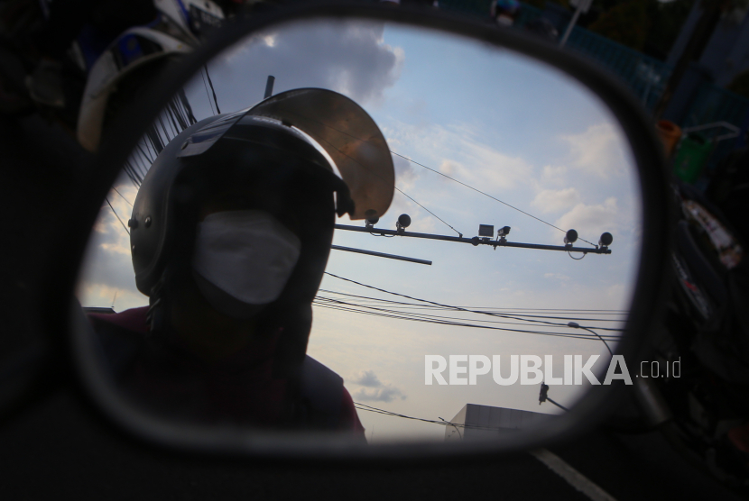 Pengendara melintas di bawah kamera pengawas atau Closed Circuit Television (CCTV) yang terpasang di Jalan Daan Mogot, Kota Tangerang, Banten, Kamis (5/1/2023). Satlantas Polresta Tangerang mulai melakukan uji coba pemberlakuan tilang elektronik.