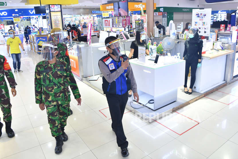 Personel TNI-Polri berpatroli di salah satu pusat perbelanjaan di Surabaya, Jawa Timur, Selasa (16/6/2020). Personel TNI-Polri dikerahkan untuk memastikan masyarakat menerapkan protokol kesehatan guna mencegah penularan virus corona COVID-19 selama masa transisi menuju normal baru