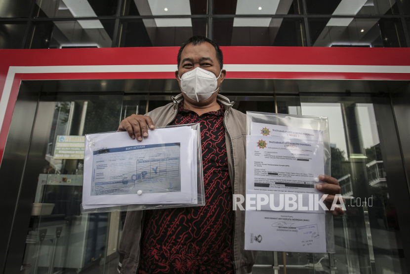 Koordinator Masyarakat Anti Korupsi Indonesia (MAKI) Boyamin Saiman menunjukkan sejumlah berkas usai menyampaikan pelaporan di gedung KPK, Jakarta.