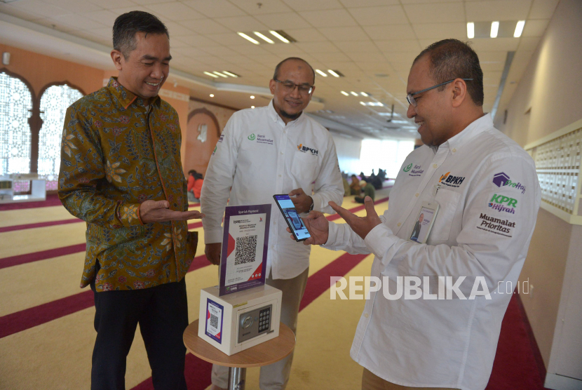 Direktur Operasi PT Bank Muamalat Indonesia Tbk Wahyu Avianto (kanan) didampingi oleh Direktur Kepatuhan Karno (kiri) dan Chief Human Capital Officer Riksa Prakoso (tengah) melakukan donasi menggunakan fitur QR Code pada aplikasi Muamalat DIN di kotak amal Masjid Al-Muamalah, Muamalat Tower, Jakarta, Kamis (12/1/2023). Fitur QR Code Muamalat DIN dapat digunakan di merchant-merchant yang terhubung dengan QRIS seperti toko ritel, SPBU hingga kotak amal. PT Bank Muamalat Indonesia Tbk terus memperluas implementasi penggunaan QR Code sebagai bagian dari upaya untuk meningkatkan penetrasi pembayaran nontunai.  