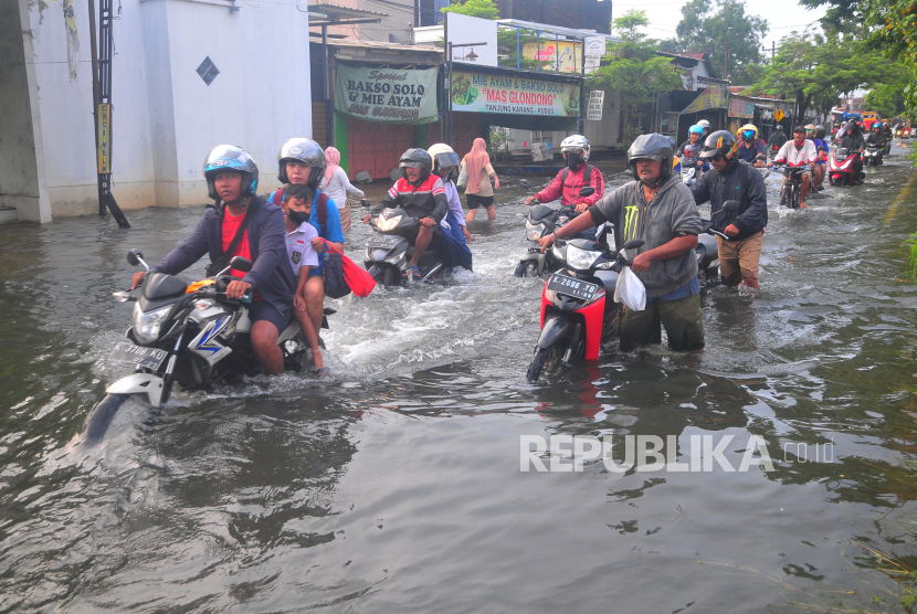 Sejumlah pengendara melintasi jalan yang tergenang banjir di Desa Tanjungkarang, Kecamatan Jati, Kabupaten Kudus, Jawa Tengah, Selasa (19/3/2024). 