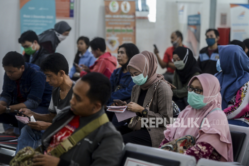 Warga antre untuk menukarkan tiket kereta api di Stasiun Pasar Senen, Jakarta, Sabtu (4/4). PT Kereta Api Indonesia (Persero) mewajibkan seluruh penumpang menggunakan masker saat naik kereta.