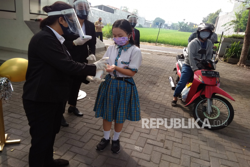Siswi mengambil hand sanitizer sebelum prosesi wisuda siswa SD di tengah pandemi Covid19 (ilustrasi)