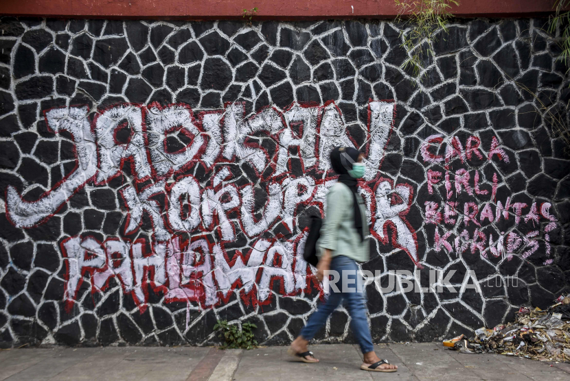 Warga melintas di depan mural yang bertuliskan Jadikan Koruptor Pahlawan (ilustrasi).. Foto: Republika/Abdan Syakura