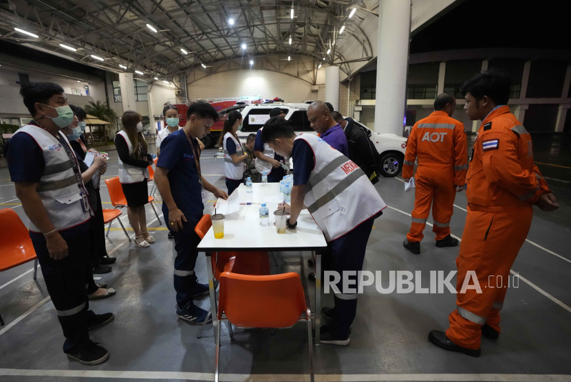 Members of a rescue team discuss after a London-Singapore flight was diverted to Bangkok due to severe turbulence, in Bangkok, Thailand, Tuesday, May 21, 2024. The plane apparently plummeted for a number of minutes before it was diverted to Bangkok, where emergency crews rushed to help injured passengers amid stormy weather, Singapore Airlines said Tuesday.  