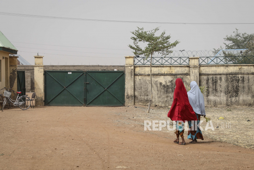  Gadis-gadis berjalan di sebelah Sekolah Menengah Pertama Gadis Pemerintah dari mana lebih dari 300 gadis diculik pada hari Jumat oleh pria bersenjata, di kota Jangebe, negara bagian Zamfara, Nigeria utara Sabtu, 27 Februari 2021. Polisi dan militer Nigeria telah memulai operasi bersama untuk menyelamatkan lebih dari 300 gadis yang diculik dari sekolah asrama, menurut juru bicara polisi.