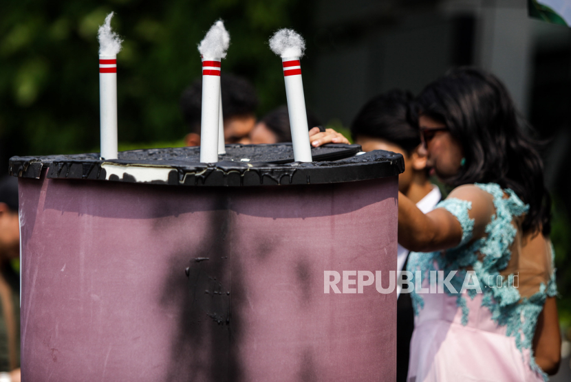 Replika kue batu bara dan lilin berbentuk cerobong asap dibawa saat aksi unjuk rasa dari Organisasi Masyarakat Sipil di Jakarta, Rabu (8/5/2024). 