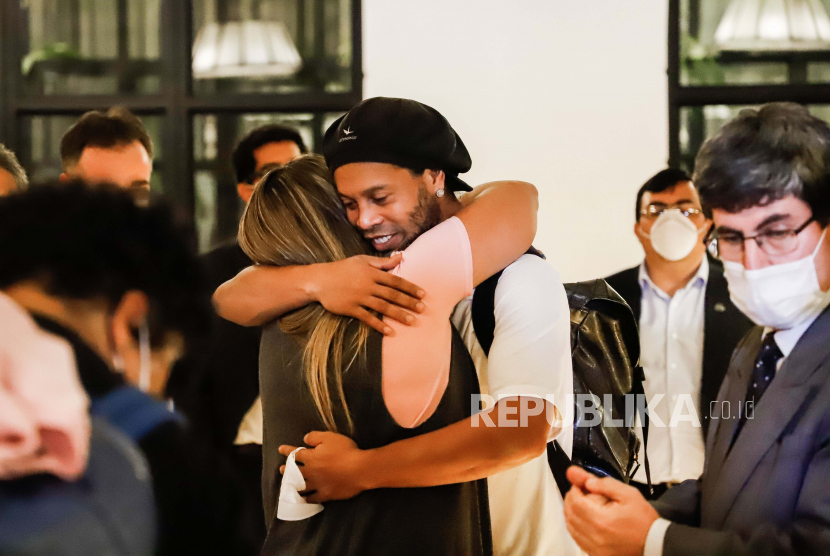 Mantan pemain sepak bola Brasil Ronaldinho Gaucho memeluk seorang teman ketika tiba di Hotel Palmaroga di Asuncion, Paraguay, Selasa (7/4). Ronaldinho dan saudaranya memasuki hotel untuk menjalani sebagai tahanan rumah setelah meninggalkan kantor polisi