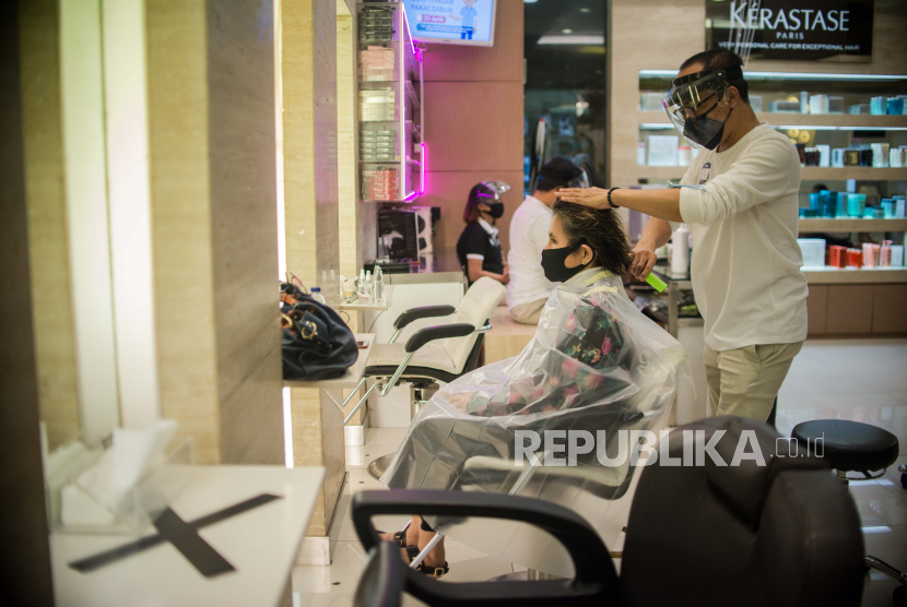 Karyawan melayani pelanggan yang melakukan perawatan rambut (ilustrasi). PSBB Proporsional, bioskop dan salon diizinkan buka dengan kapasitas 30 persen