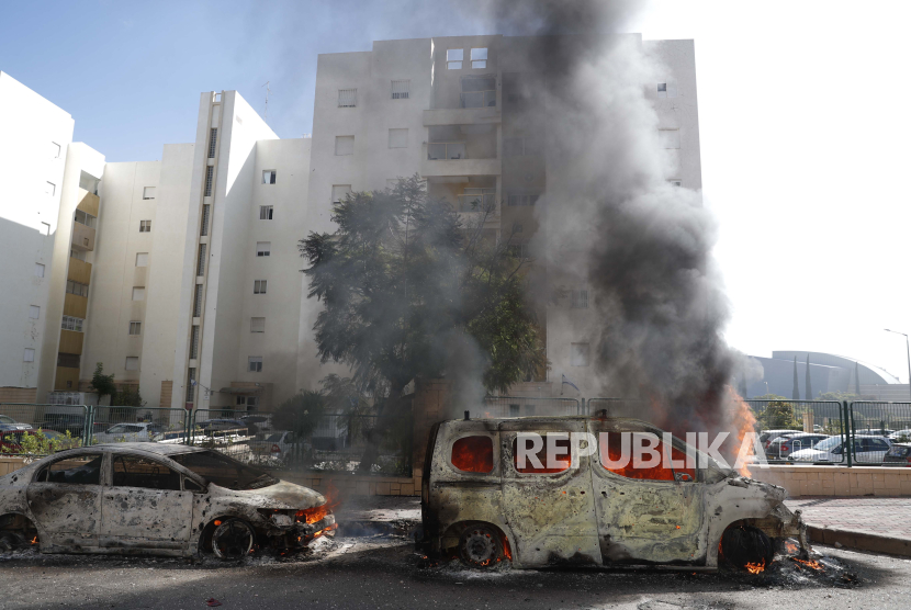 Sebuah kendaraan terbakar di kota Ashkelon di Israel setelah peluncuran roket dari Gaza, 07 Oktober 2023. Rentetan roket diluncurkan dari Jalur Gaza Sabtu pagi dalam serangan mendadak yang diklaim ole