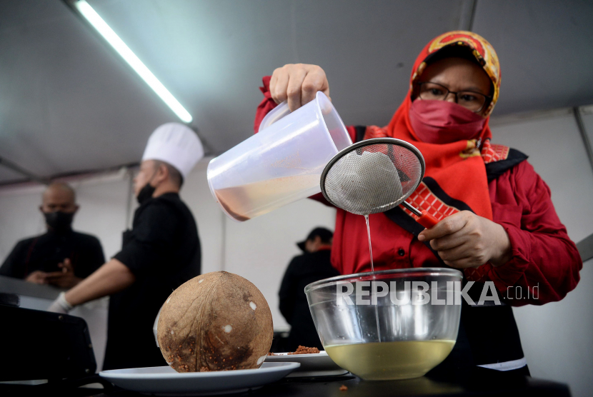 Kader PDI Perjuangan meyaring minyak kelapa ketika mengikuti acara demo memasak tanpa minyak goreng di Sekolah Partai PDIP, Jakarta, Senin (28/3/2022). 