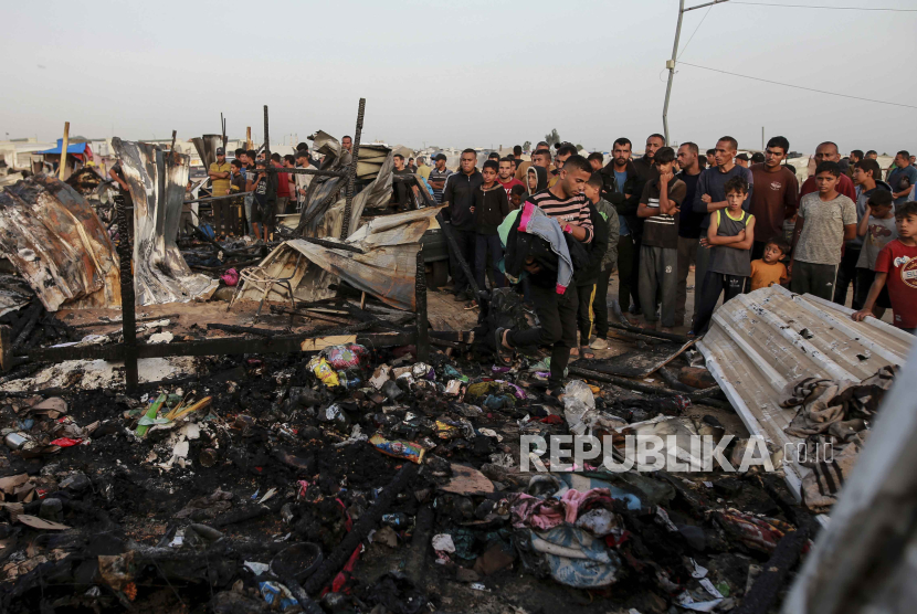  Warga Rafah di tengah-tengah puing akibat serangan Israel. Serangan Israel ke Rafah menewaskan 30 orang 