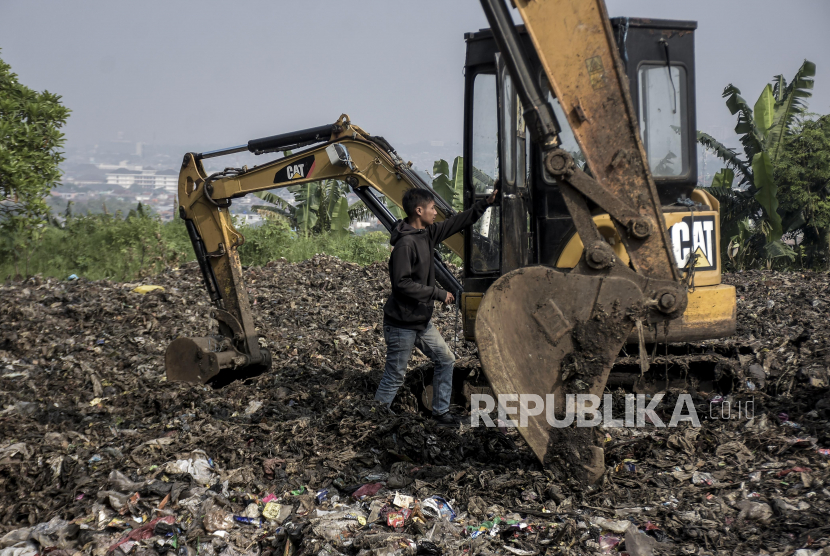Pekerja beraktivitas di area Tempat Pembuangan Sampah (TPS) ilustrasi 
