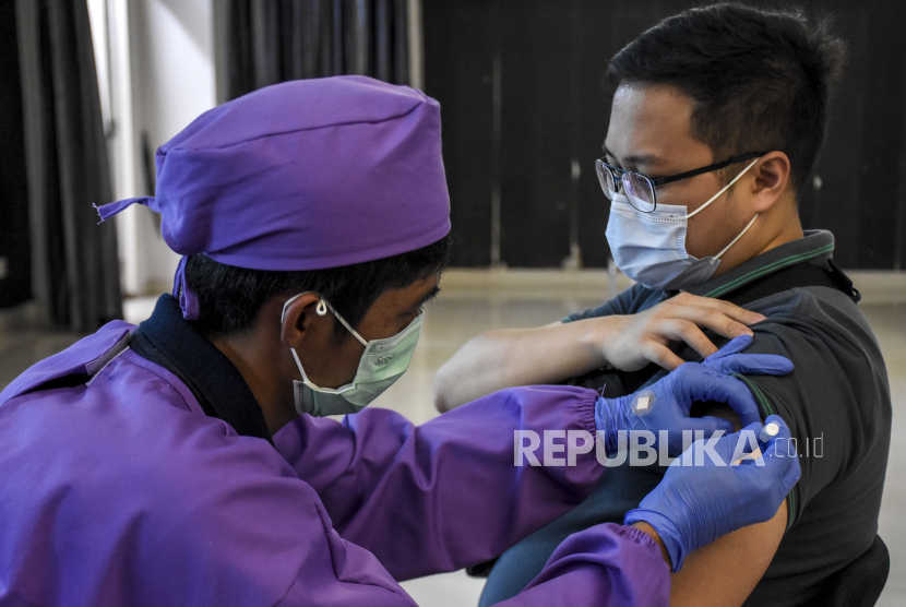 Vaksinator menyuntikkan vaksin Covid-19 Sinovac ke tenaga kesehatan saat vaksinasi Covid-19 massal di Poltekkes Kemenkes Bandung, Jalan Pajajaran, Kota Bandung, Ahad (31/1). Sedikitnya 3.300 tenaga kesehatan serta sumber daya manusia (SDM) di lingkungan kesehatan Provinsi Jawa Barat mengikuti vaksinasi Covid-19 secara massal dan serentak di 24 fasilitas kesehatan sebagai upaya percepatan capaian target vaksinasi Covid-19. Foto: Abdan Syakura/Republika