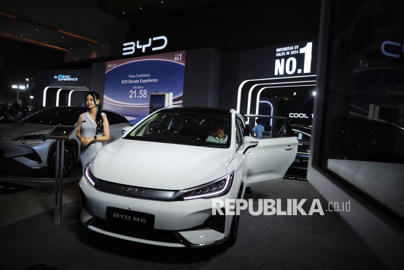 Seorang model berdiri di dekat mobil listrik di salah satu stan pada ajang Periklindo Electric Vehicle Show (PEVS) 2025 di JIExpo Kemayoran, Jakarta, Selasa (29/4/2025).