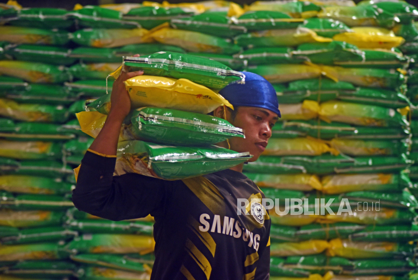 Pekerja mengangkut paket beras SPHP ukuran 5 kilogram untuk dikirim ke pasar-pasar, di Serang, Banten, Kamis (15/2/2024).