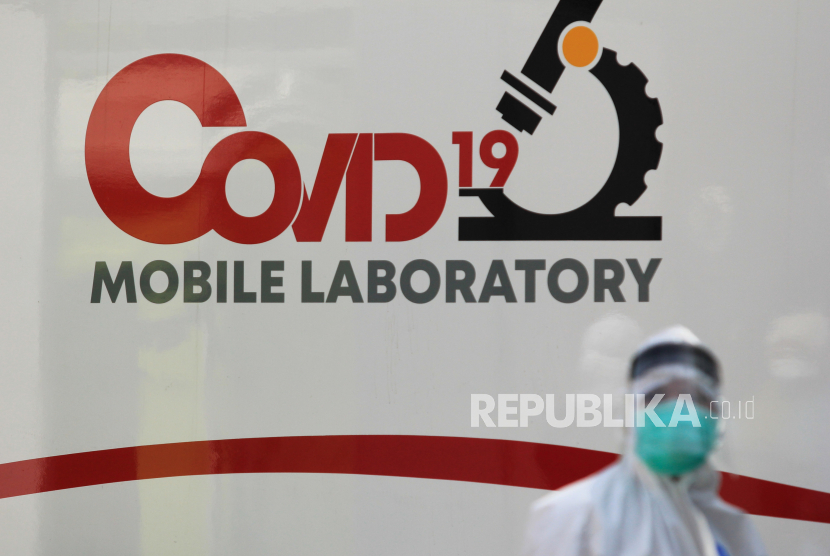 Petugas kesehatan mengenakan APD melintas di dekat mobil laboratorium Covid-19 saat tes cepat Covid-19 massal di kawasan Mulyorejo, Surabaya, Jawa Timur, Rabu (17/6). (ilustrasi)