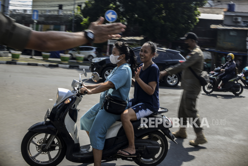 Petugas Satpol PP menghentikan pengendara motor yang tidak memakai masker di Jalan Minangkabau, Manggarai, Jakarta Selatan, Rabu (9/2/2022). 