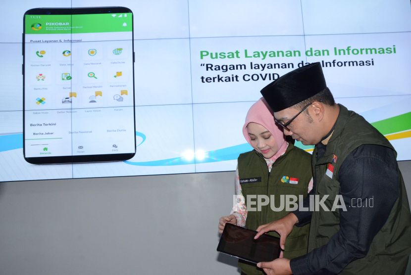 Gubernur Jawa Barat Ridwan Kamil (kanan) bersama Ketua Jabar Bergerak Atalia Praratya mencoba aplikasi Pusat Informasi dan Koordinasi COVID-19 (Pikobar).