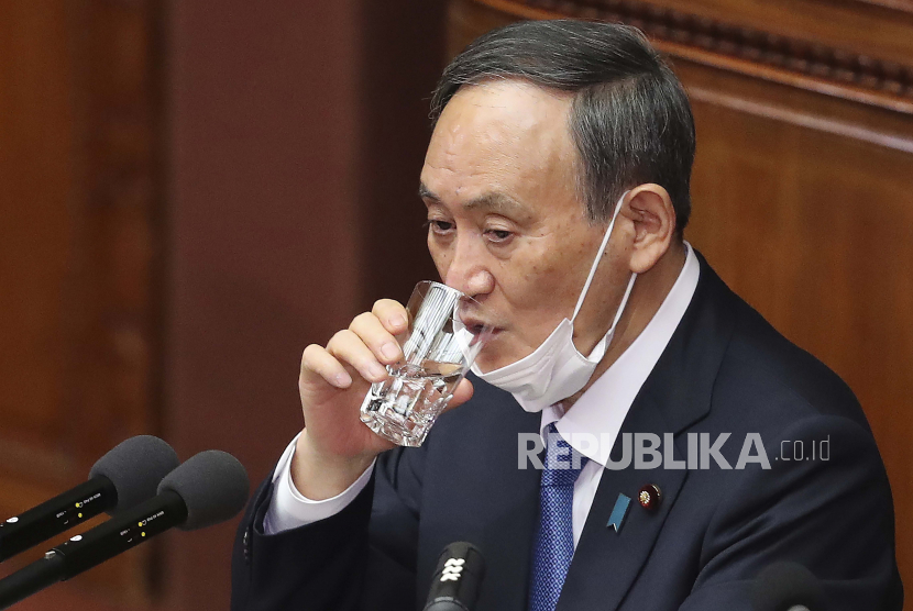Perdana Menteri Jepang Yoshihide Suga minum air selama sesi Diet biasa di majelis tinggi parlemen di Tokyo, Senin, 18 Januari 2021. Suga berjanji Senin untuk mengendalikan pandemi dan mengadakan Olimpiade yang sudah ditunda musim panas ini dengan banyak virus korona perlindungan.
