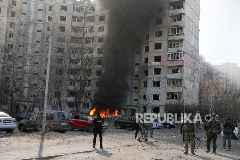 Petugas pemadam kebakaran dan tim keamanan Ukraina di lokasi sebuah gedung yang terkena rudal Rusia di Kyiv (Kiev), Ukraina, 20 Maret 2022.