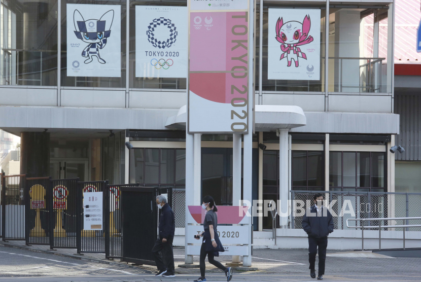  Orang-orang berjalan melewati poster untuk mempromosikan Olimpiade, di Tokyo, Selasa (16/2). Olimpiade dijadwalkan dibuka pada 23 Juli, tetapi jajak pendapat baru-baru ini menunjukkan sekitar 80% publik Jepang ingin Olimpiade dibatalkan atau ditunda.