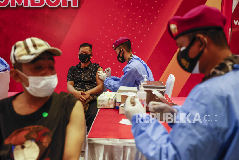 Seorang pria (kiri, belakang) bereaksi saat menerima dosis vaksin Sinovac COVID-19 selama kampanye vaksinasi yang diselenggarakan oleh Polri dan TNI di Mabes Polri di Depok, Jawa Barat, Indonesia, 20 Oktober 2021 .