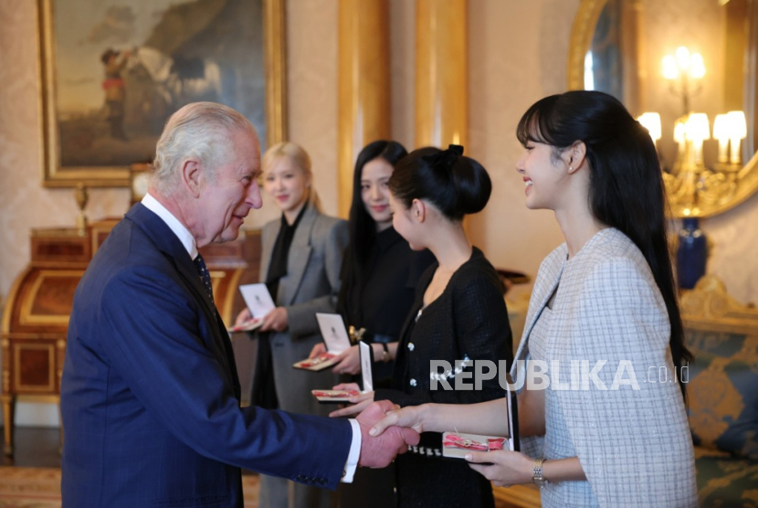 Lisa (R), a member of K-pop girl group BLACKPINK, receives the Honorary Member of the Order of the British Empire from Britain