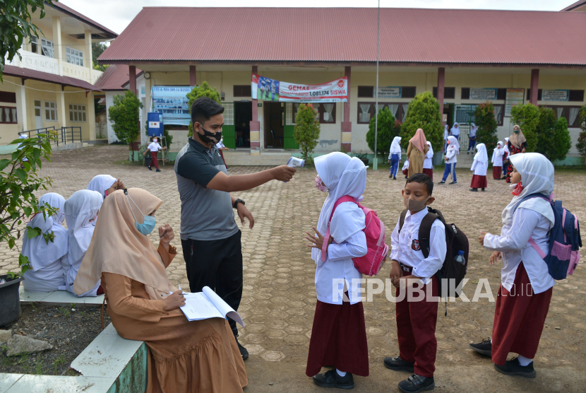 Kekurangan tenaga guru terjadi di Jawa Timur. Foto, guru melakukan pengecekan suhu badan dan penggunaan masker murid pascapenutupan sekolah  (ilustrasi)