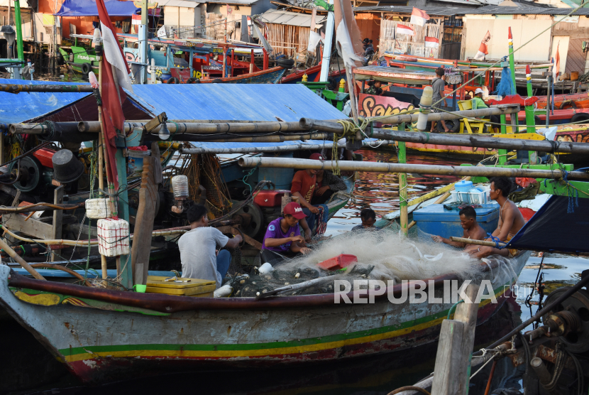 Nelayan memperbaiki jaring di atas perahunya di perkampungan nelayan Cilincing, Jakarta. Sekjen Koalisi Rakyat untuk Keadilan Perikanan (Kiara) Susan Herawati mengatakan pemerintah diharapkan memberikan perhatian kepada nelayan dan pelaku perikanan rakyat yang pendapatannya menurun akibat pandemi COVID-19 karena terputusnya rantai dagang dari nelayan kepada masyarakat
