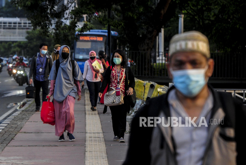 Sejumlah karyawan swasta berjalan saat jam pulang kerja di kawasan Sudirman, Jakarta, Senin (8/6). Sejumlah perusahaan swasta di Jakarta sudah mulai aktif dan menerapkan kerja di kantor pada Senin (8/6) di masa transisi pembatasan sosial berskala besar (PSBB)