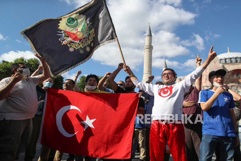 Orang-orang memegang bendera Turki dan Ottoman di depan Museum Hagia Sophia, di Istanbul, Turki, 10 Juli 2020. Pengadilan administrasi tertinggi Turki pada 10 Juli 2020 memutuskan bahwa museum yang dulunya masjid yang dibangun di Katedral dapat diubah menjadi sebuah masjid lagi dengan menetapkan statusnya sebagai museum.