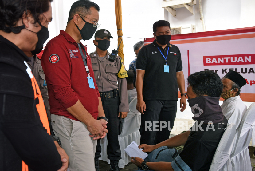 Menteri Sosial Juliari Batubara (kedua kiri) berbincang dengan warga penerima bantuan saat meninjau penyaluran Bantuan Sosial Tunai (BST) di Kantor Pos Serang, Banten, Sabtu (9/5/2020). Sebanyak 343