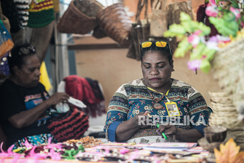 Mama-mama Papua membuat kerajinan tangan dari bahan daun kelapa di sebuah stan pameran. ilustrasi