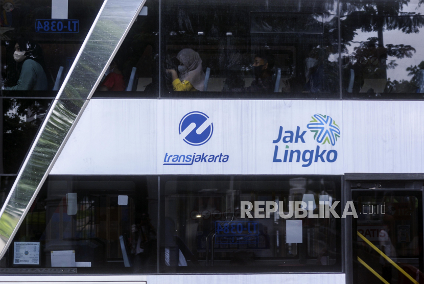 Sejumlah warga menaiki bus wisata Transjakarta di Halte IRTI Monas, Jakarta Pusat, Rabu (21/12/2022).