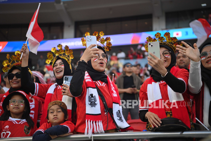 Sejumlah suporter Indonesia  meneriakkan yel-yel  dukungan kepada Timnas Indonesia yang bertanding melawan Timnas Jepang di babak penyisihan  grup D Piala Asia 2023 di Stadion Al Thumama, Doha, Qatar, Rabu (24/1/2024). 