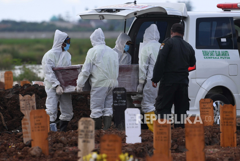 Petugas membawa peti jenazah untuk dimakamkan dengan protokol Covid-19 di TPU Rorotan, Cilincing, Jakarta Utara.