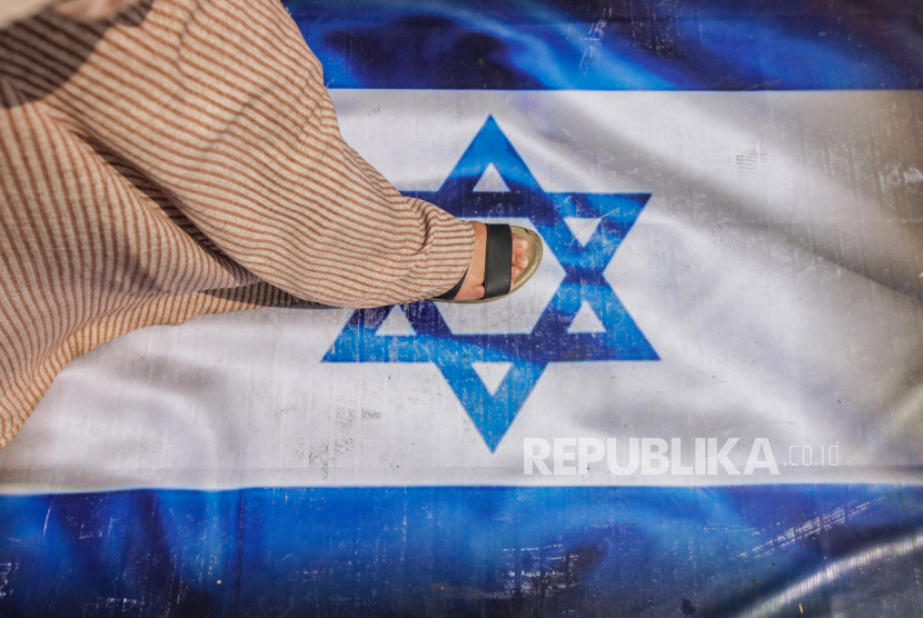 Warga menginjak spanduk bergambarkan Bendera Israel (Ilustrasi). Tokoh Zionisme Israel  Theodor Herzl munclkan kandidat tanah dijanjikan  