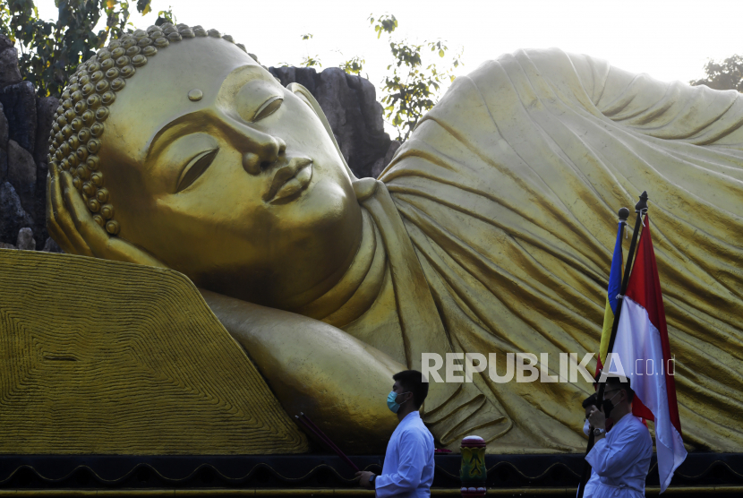 Umat mengelilingi Patung Buddha Tidur saat peringatan Waisak 2565 BE di Maha Vihara Mojopahit Trowulan, Mojokerto, Jawa Timur, Rabu (26/5/2021). Peringatan Hari Tri Suci Waisak tersebut dibatasi dan hanya diikuti sekitar 50 umat untuk mengantisipasi penyebaran COVID-19. 