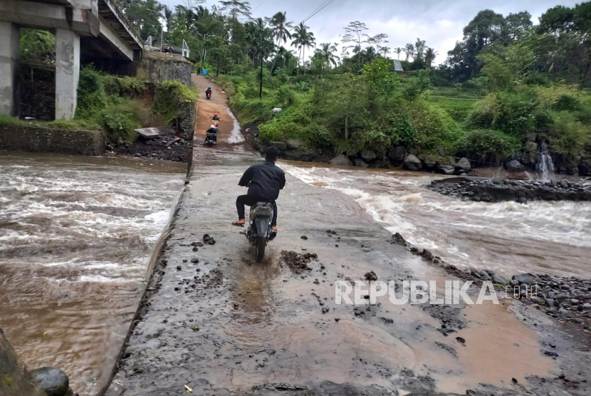 Pengguna kendaraan melintasi cekdam yang berada di bawah Jembatan Cidugaleun, Kecamatan Cigalontang, Kabupaten Tasikmalaya, Jawa Barat, Senin (8/5/2023) sore. 