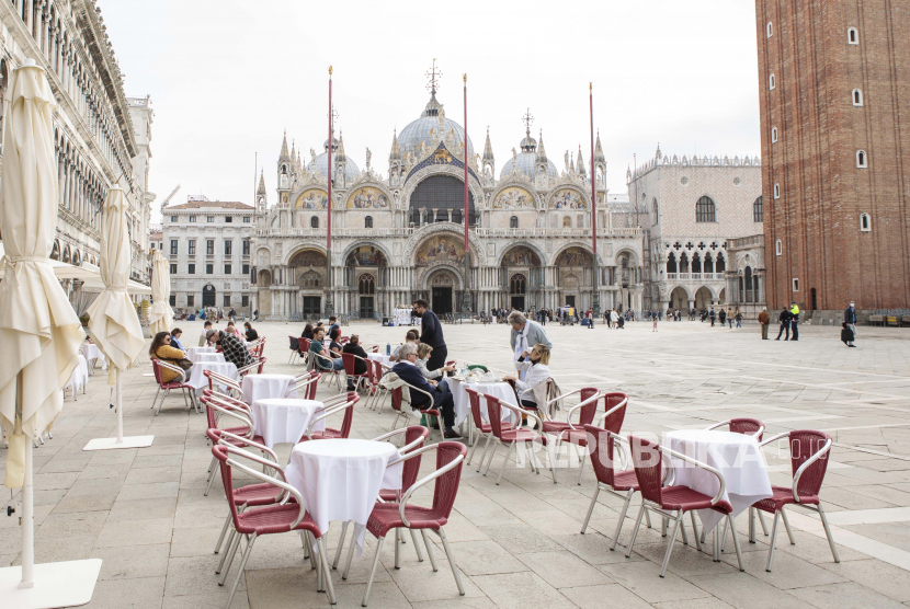 Orang-orang duduk di Lapangan Santo Markus di Venesia, Italia utara, Sabtu, 1 Mei 2021. Italia secara bertahap dibuka kembali setelah enam bulan penutupan virus bergilir yang memungkinkan makan di luar ruangan.