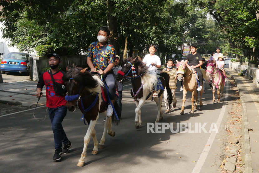 Sejumlah anak menunggang kuda sewa berkeliling taman di kawasan Taman Lansia, Jalan Cisangkuy, Kota Bandung. Disbudpar Bandung sebut meski kasus Covid-19 naik tapi tempat wisata belum dibatasi.