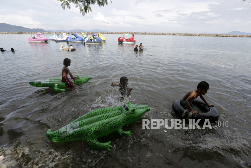 Anak-anak berenang menggunakan pelampung mainan di tengah pandemi COVID-19 di pantai Ule Lhuee, Aceh, Jumat (30/10/2020). Pariwisata menjadi sektor yang paling menderita kerugian akibat pembatasan perjalanan oleh semua negara di dunia akibat pandemi virus corona. Indonesia telah kehilangan sekitar Rp 85 triliun (5,87 miliar dolar AS) pendapatan pariwisata sepanjang tahun ini.