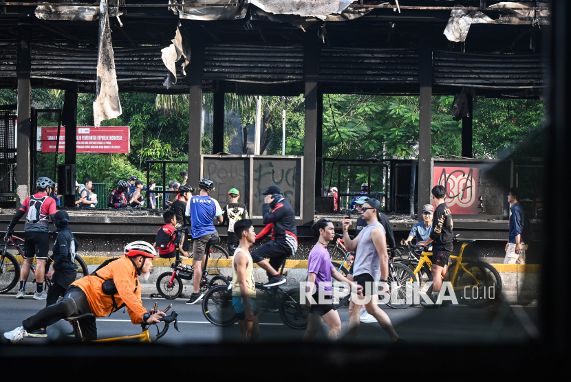 Warga berolahraga saat Hari Bebas Kendaraan Bermotor (HBKB) di dekat Halte Polda Metro Jaya yang hangus terbakar di Jalan Jenderal Sudirman, Jakarta, Ahad (31/8/2025). Gubernur DKI Jakarta Pramono Anung Wibowo menyebutkan kegiatan Car Free Day (CFD) atau HBKB di Jakarta tetap diadakan pasca eskalasi unjuk rasa sebagai upaya menunjukkan bahwa Jakarta merupakan kota yang aman. 