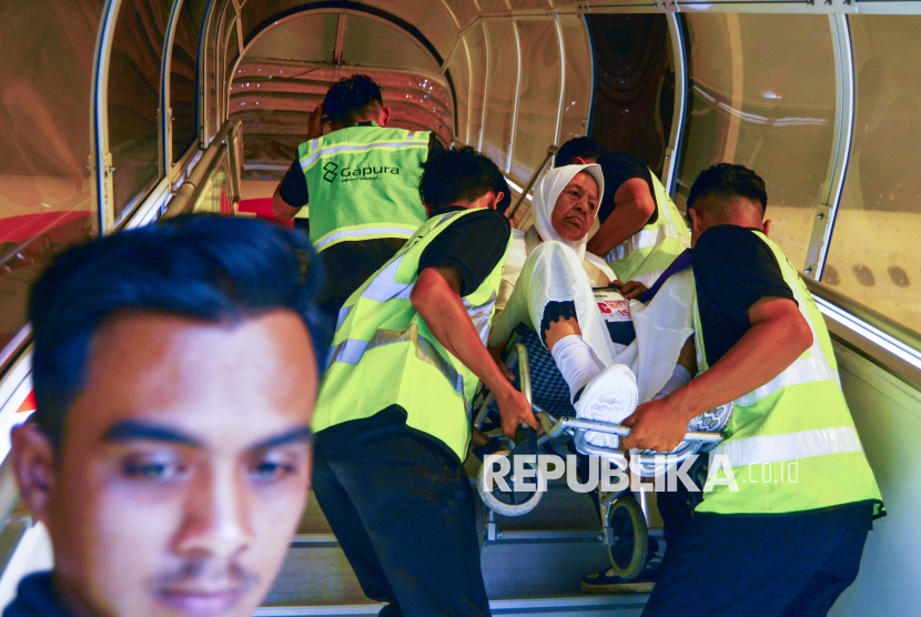 Petugas menggotong calon haji lansia menaiki pesawat di Bandara Internasional Minangkabau (BIM), Padang Pariaman, Sumatera Barat, Sabtu (3/5/2025). Sebanyak 423 calon haji tergabung dalam kloter pertama Embarkasi Padang diberangkatkan ke tanah suci dengan maskapai Lion Air. 