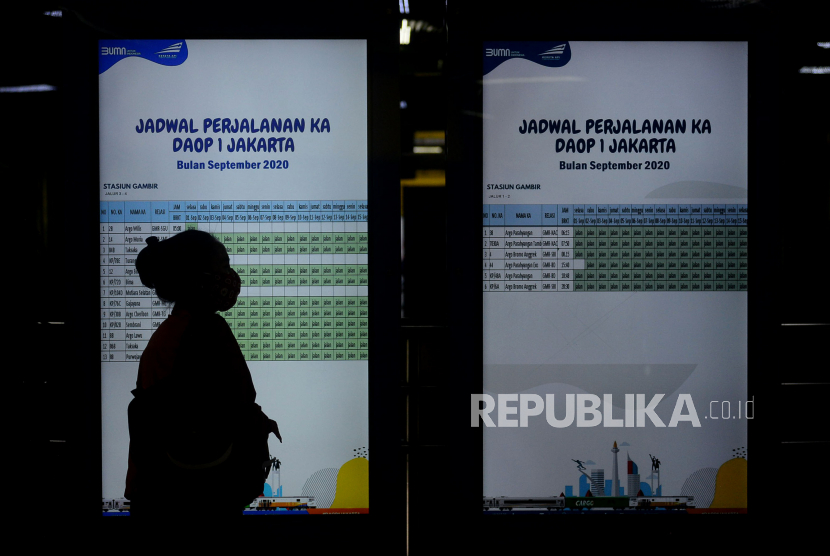 Calon penumpang mengamati jadwal perjalanan kereta di Stasiun Gambir, Jakarta, ilustrasi