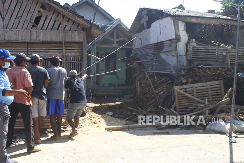 Warga dan relawan merobohkan rumah korban gempa di Majangtengah, Malang, Jawa Timur, Senin (12/4/2021). Hal tersebut dilakukan untuk mengantisipasi jatuhnya korban lagi karena banyak bangunan korban gempa sudah tidak layak huni. 