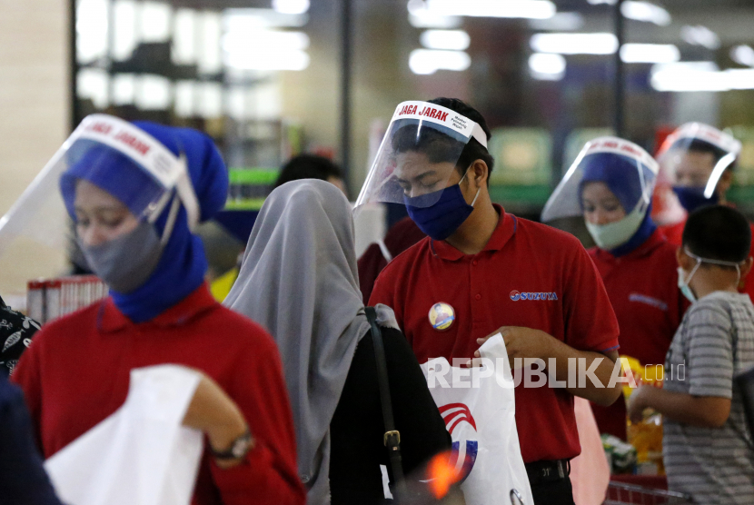 Petugas kasir salah satu pusat perbelanjaan memakai pelindung wajah (face shield) dan masker saat melayani konsumen di Banda Aceh, Aceh, Selasa (19/5/2020). Pemakaian face shield dianggap lebih melindungi orang dari risiko penularan Covid-19 daripada masker kain.