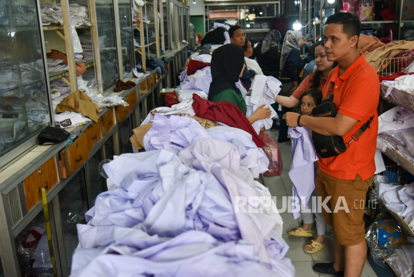 Pedagang melayani calon pembeli saat memilih seragam sekolah yang dijual. Disdik DKI Jakarta belum menerima surat resmi terkait aturan seragam baru.